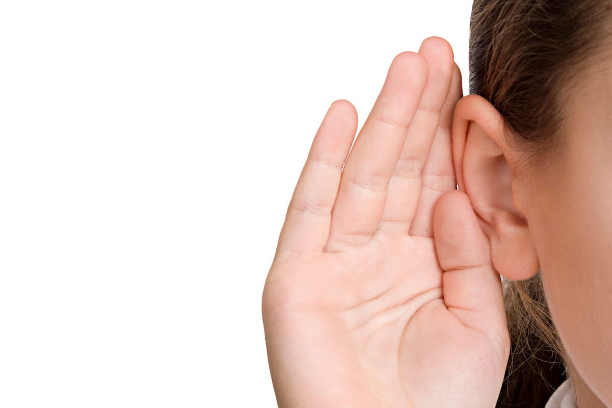 Person cupping their hand to their ear to listen