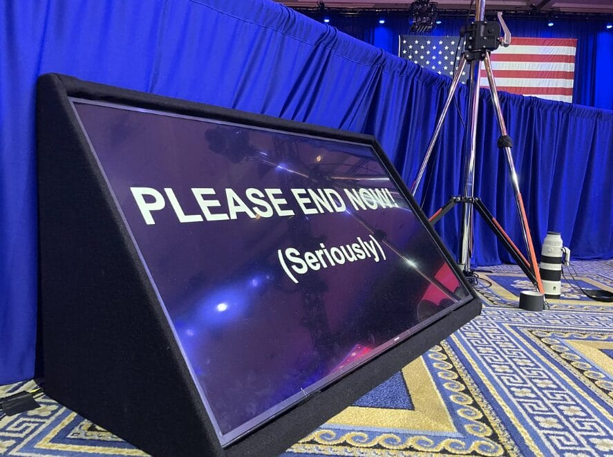 Stage confidence monitor with the message "PLEASE END NOW! (Seriously)"