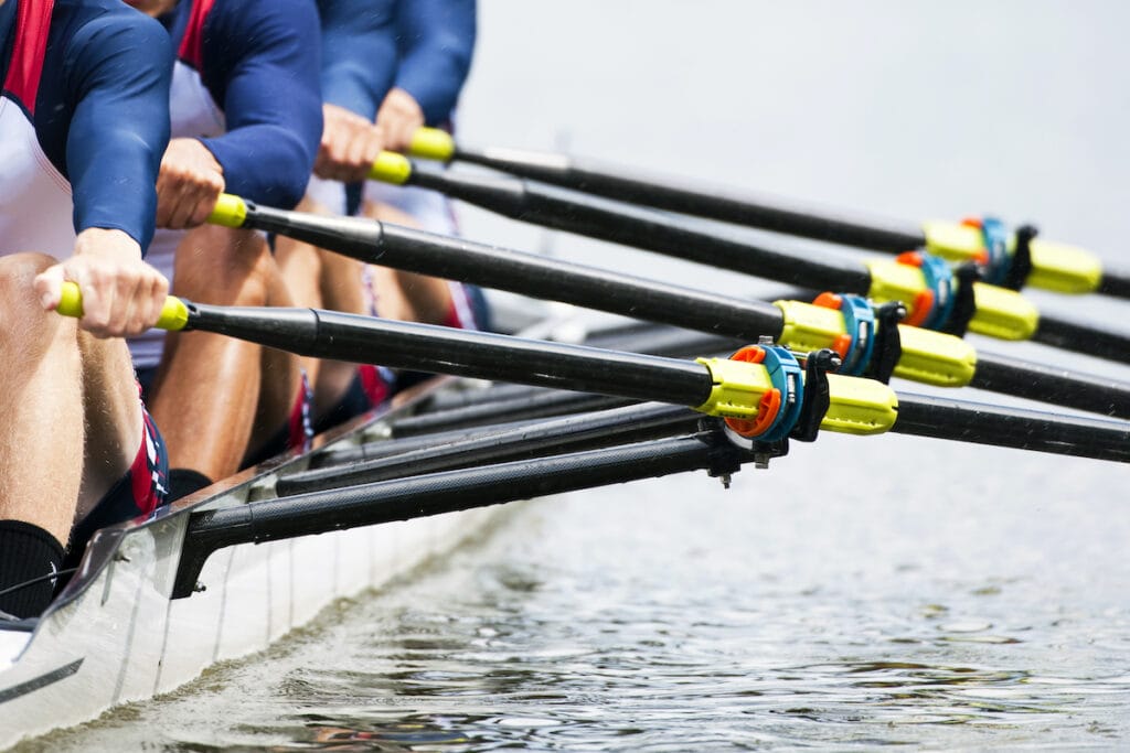 5 tips for handling group presentations. Close up of a men's quadruple skulls rowing team, seconds after the start of their race
