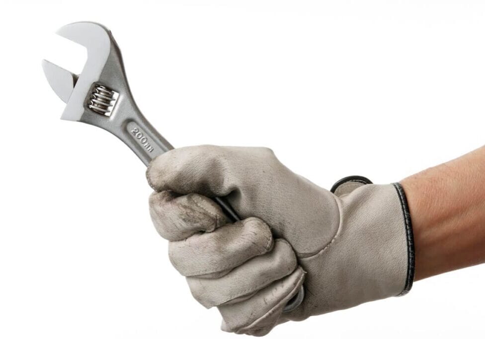 A worker's gloved hand holding a wrench. Improve your presentation skills.